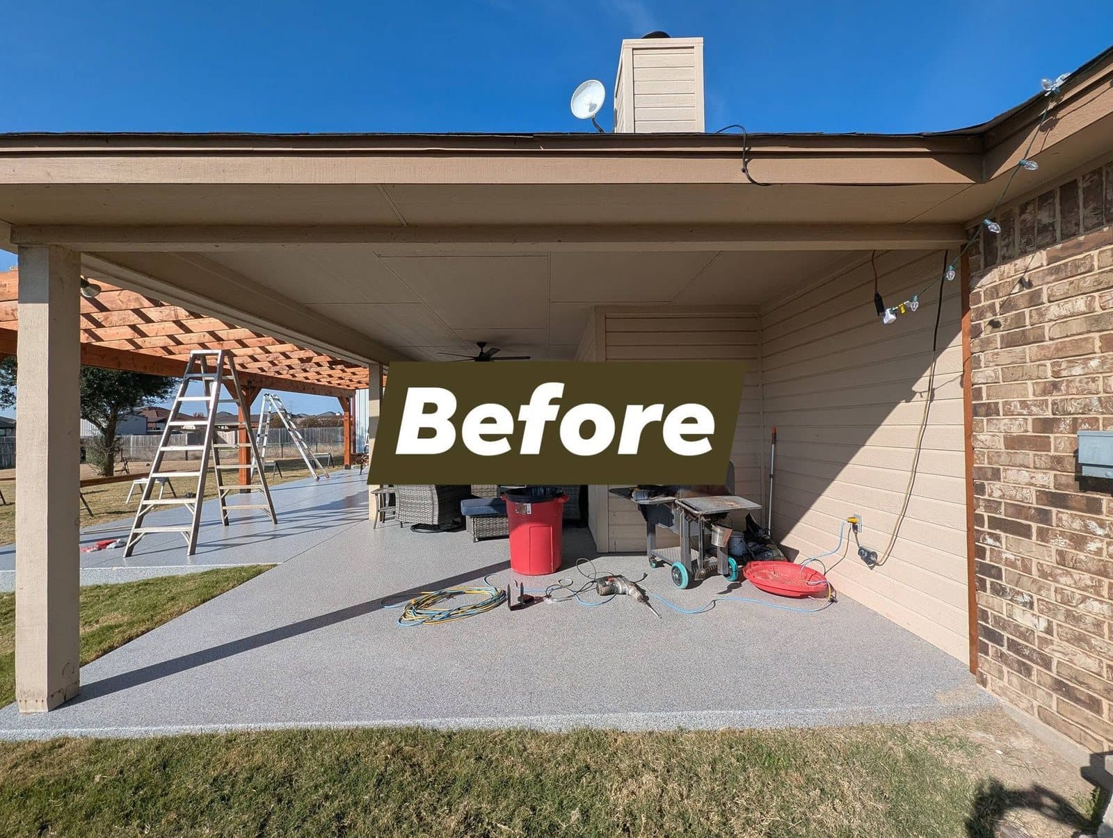 Covered patio before the work, open at the end with tools and a grill on the slab
