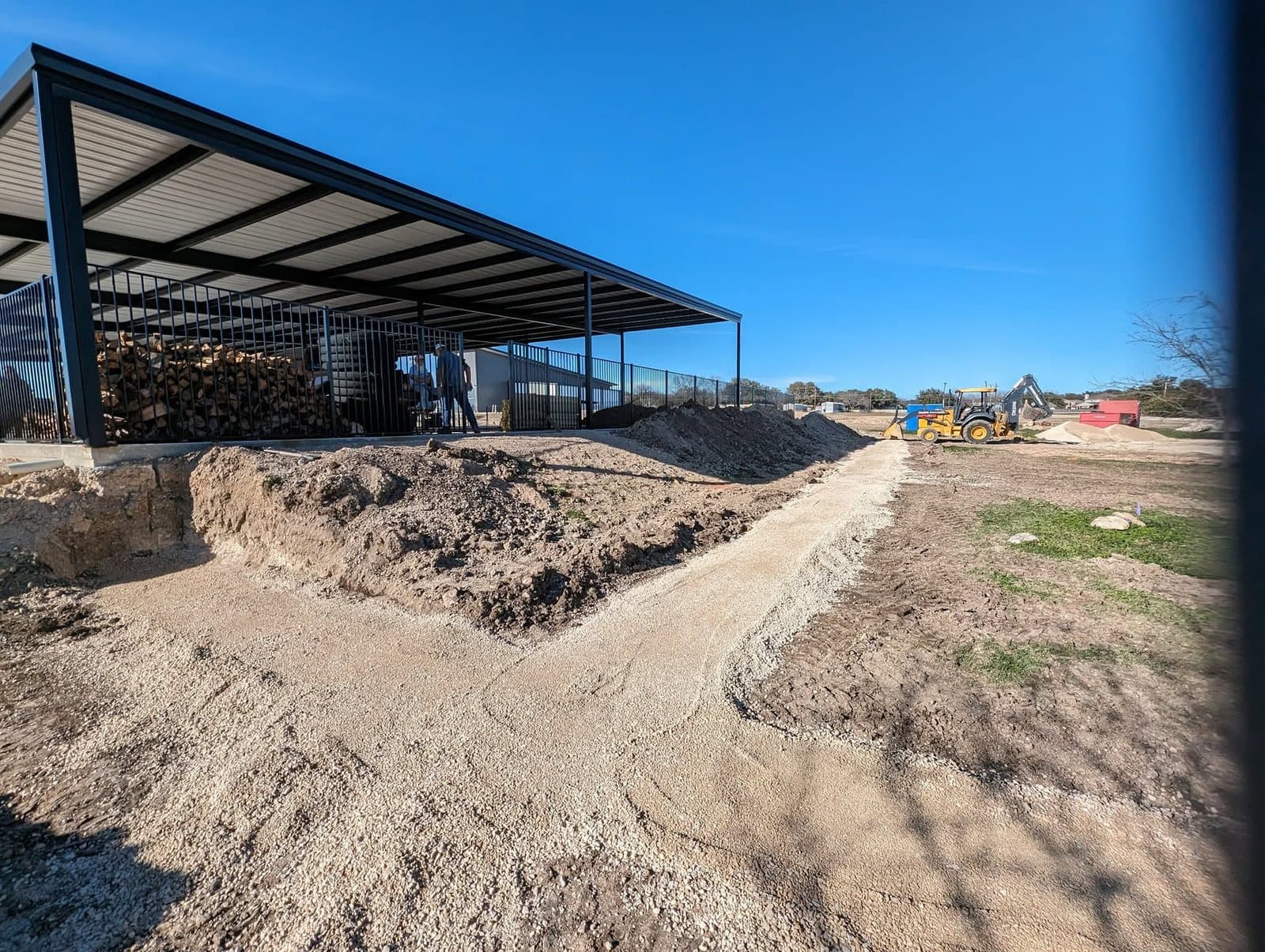 Excavated and graded footing with a compacted gravel base beside the pavilion