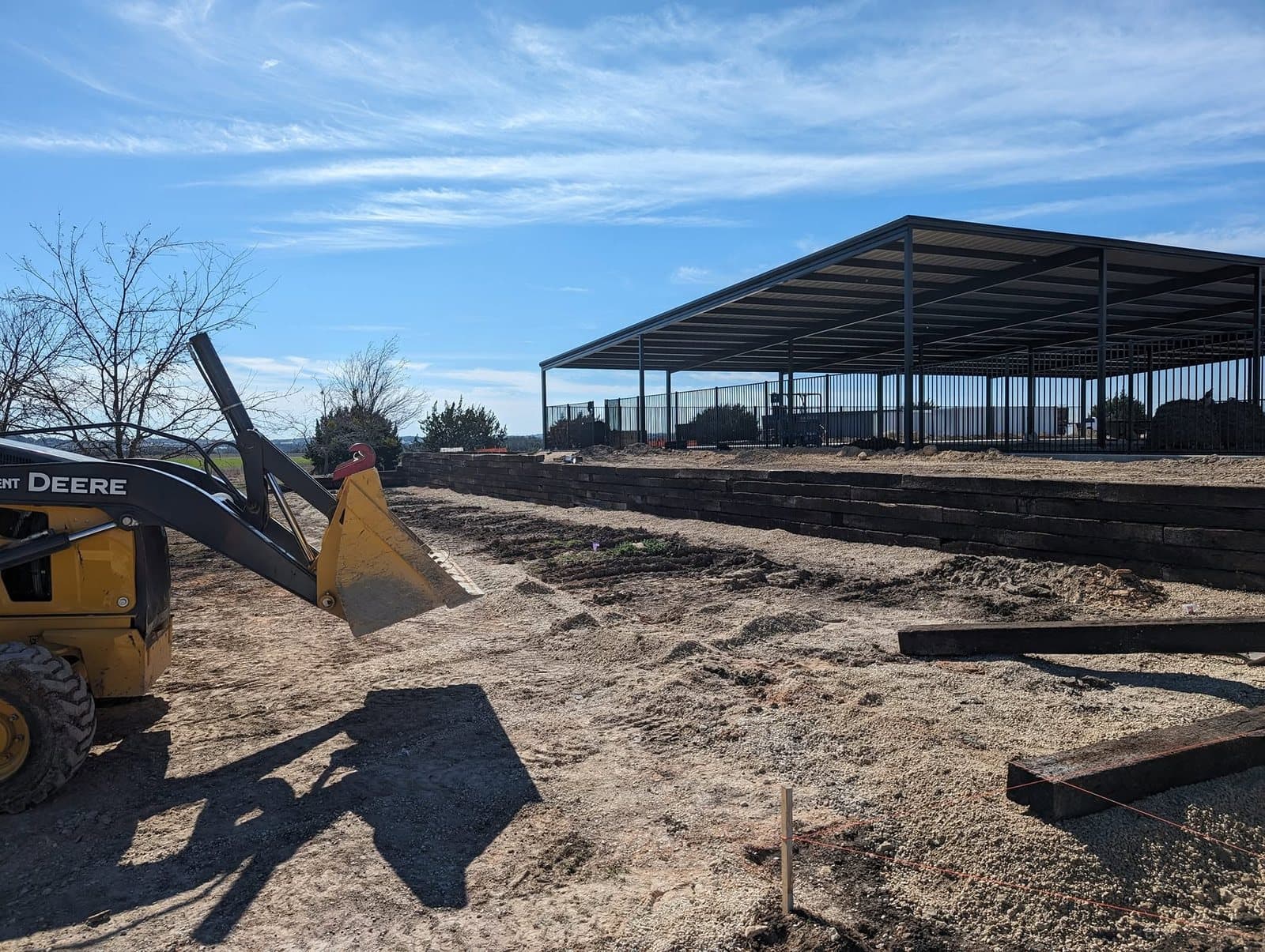 Finished timber retaining wall with the loader that graded the site in the foreground