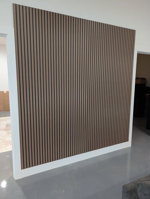 Floor-to-ceiling wood slat accent wall in a bright room